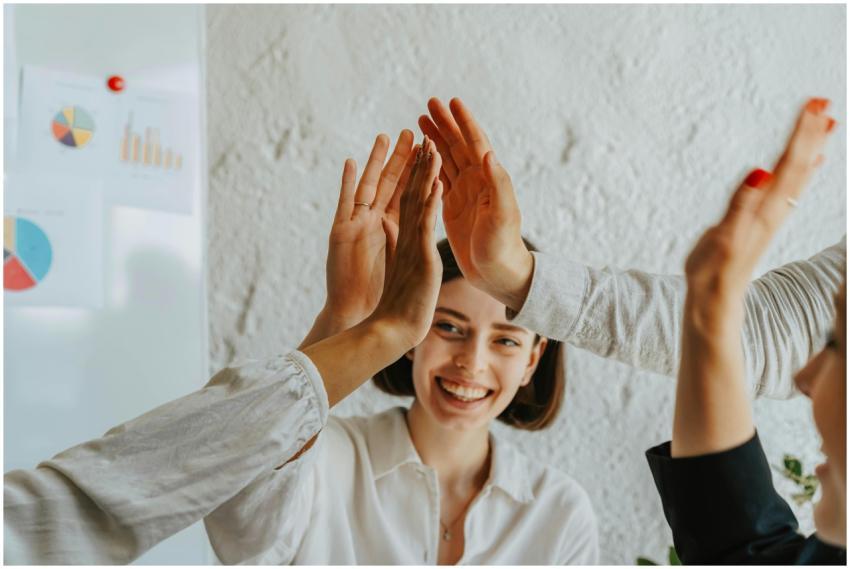 Group of smiling adults engaging in a teamwork hig