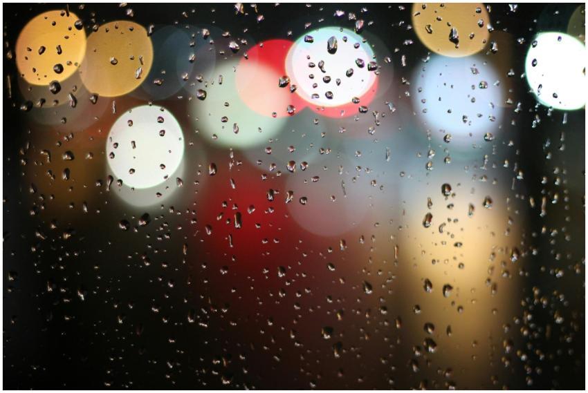 Colorful bokeh lights behind raindrop-covered wind