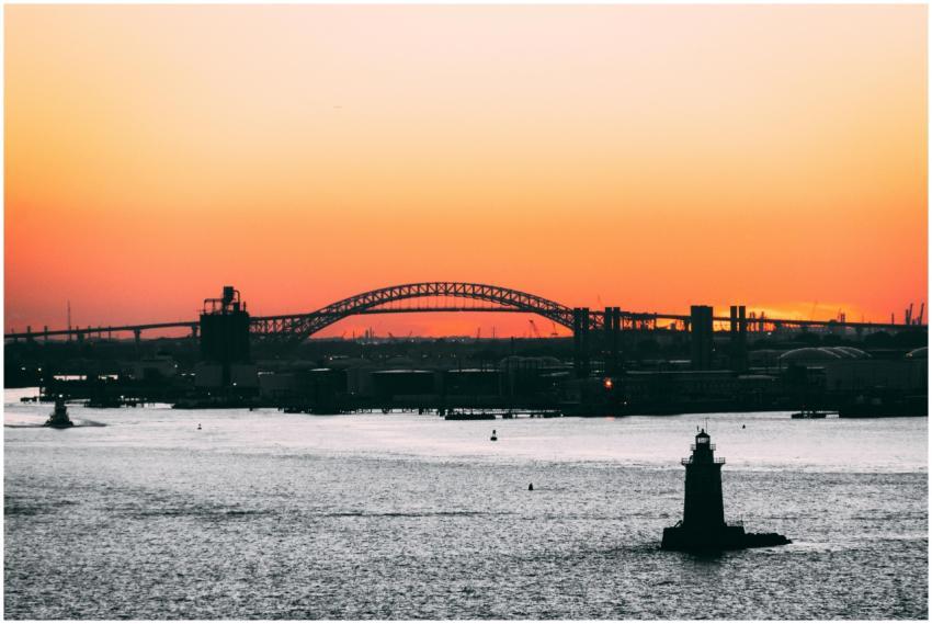 A stunning sunset over an urban bridge with a ligh