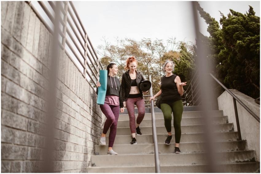 Three women walking down steps outdoors, carrying