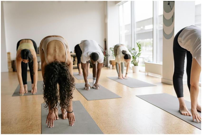 A diverse group performing yoga forward bend pose