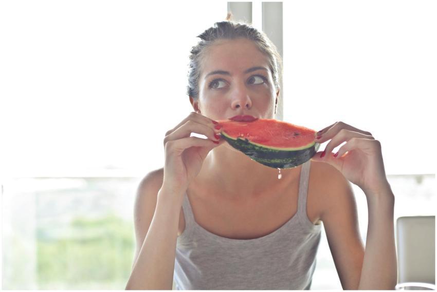 Portrait of a woman eating watermelon indoors, ref