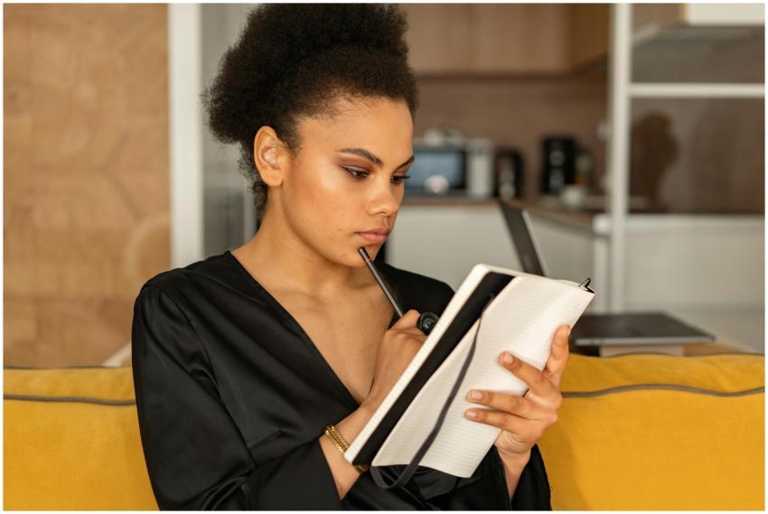 Focused woman in black attire pens thoughts in a n