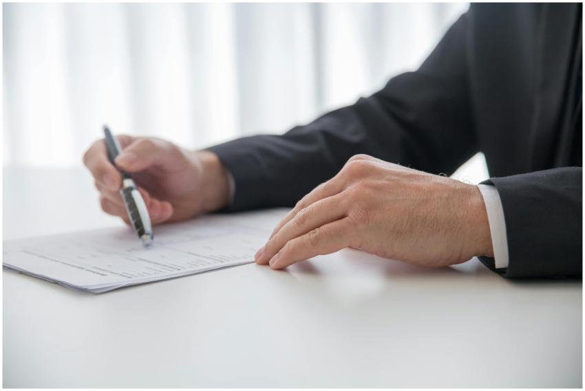 Businessman signing important documents at office