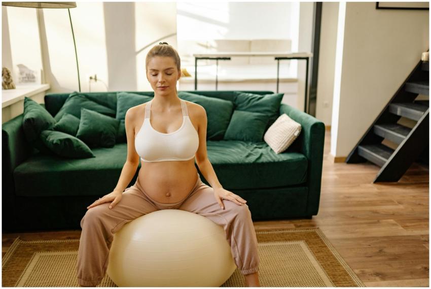 Expectant mother meditating on gym ball indoors fo