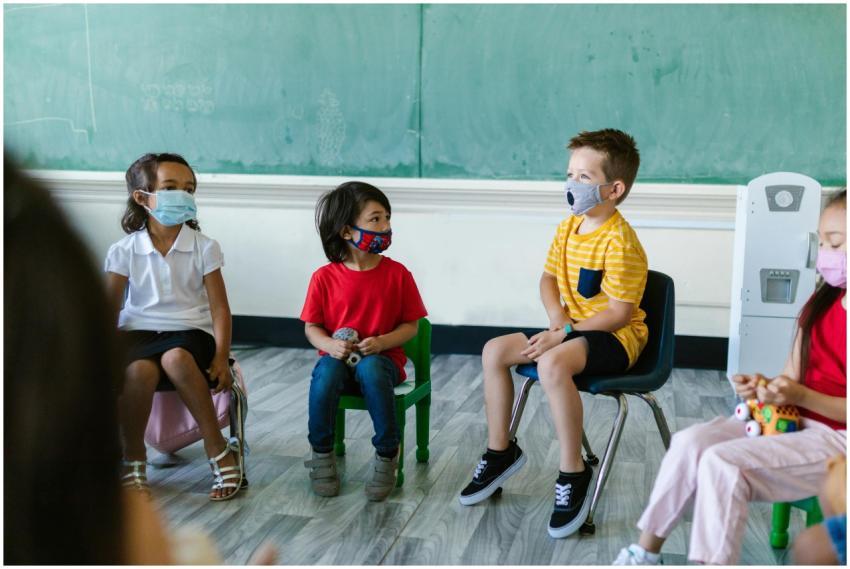 Group of children sitting in a classroom wearing f