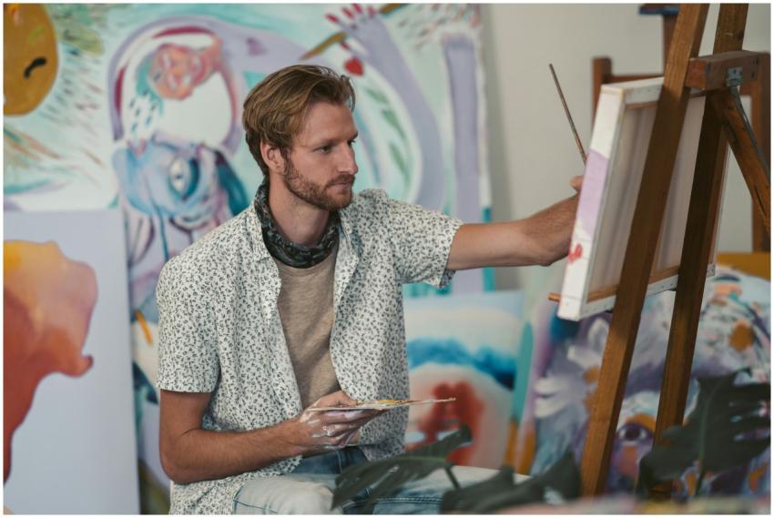 Bearded male artist painting on canvas in a vibran