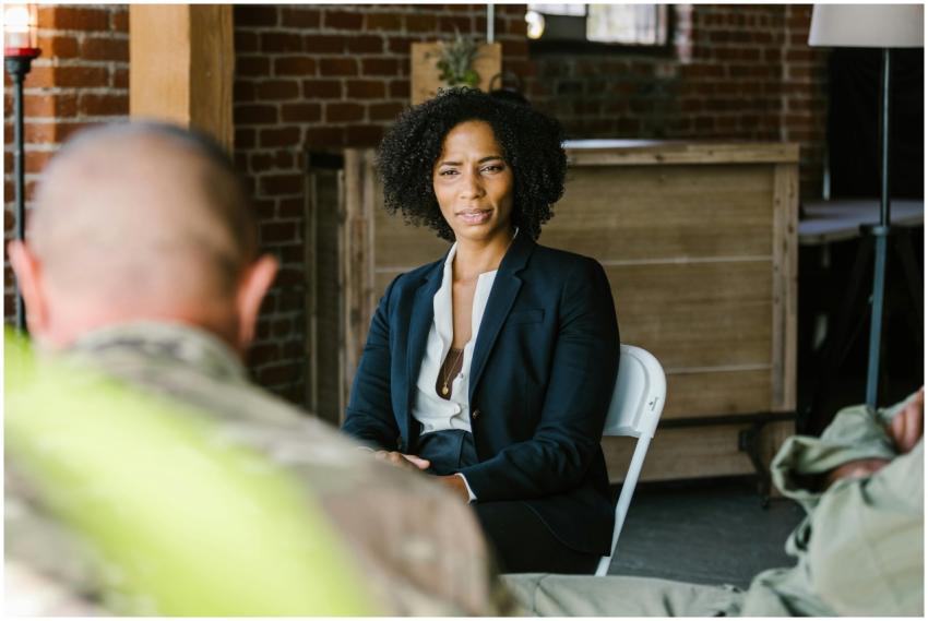 A therapist leads a group therapy session with mil