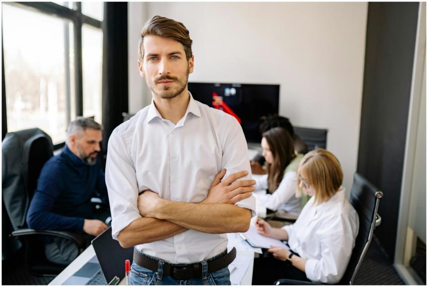 Businessman stands confidently with team in a mode