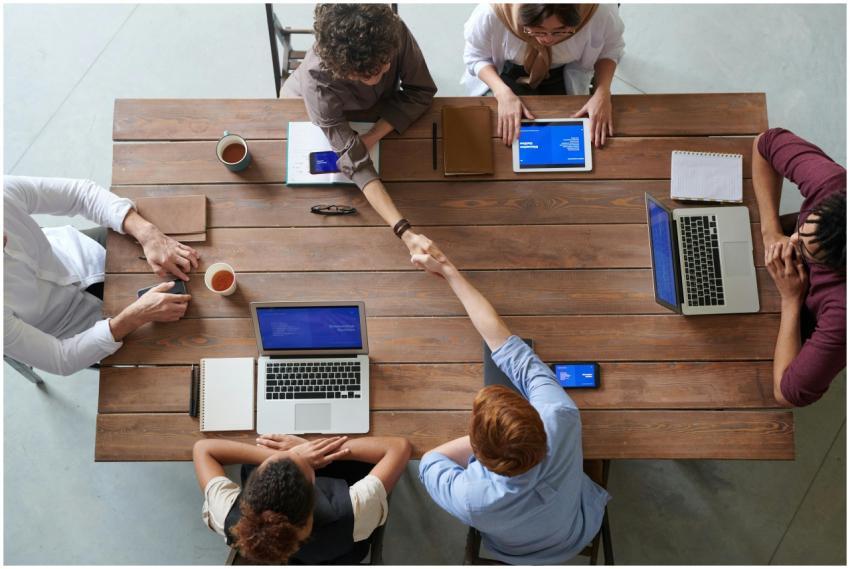 Overhead view of colleagues in a work meeting usin