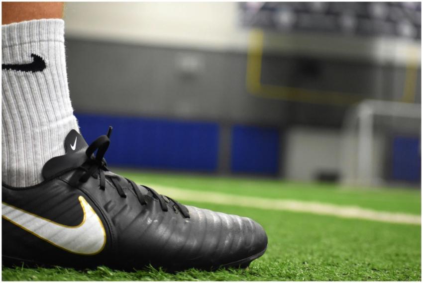 A detailed shot of a soccer cleat on an indoor tur