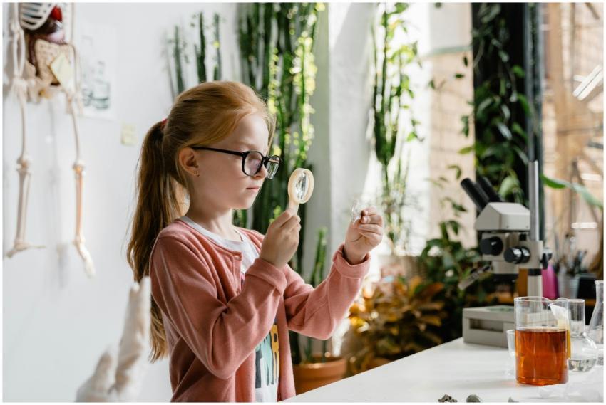 A young girl uses a magnifying glass to study samp
