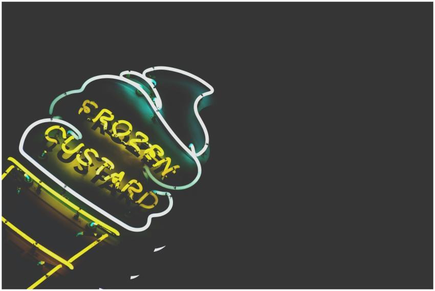 Vibrant neon frozen custard sign glowing against a