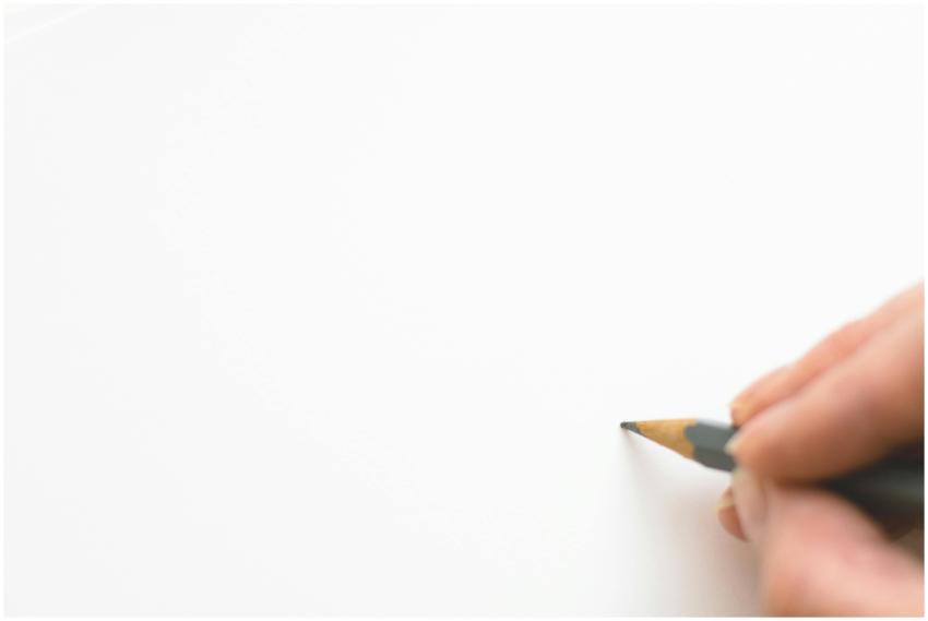 Close-up of a hand sketching on white paper with a