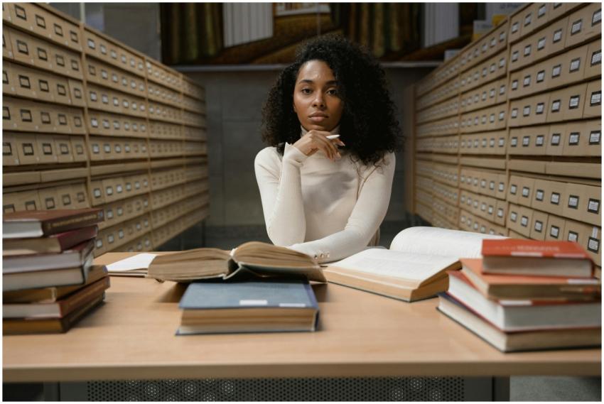 African American woman studying with books in a li