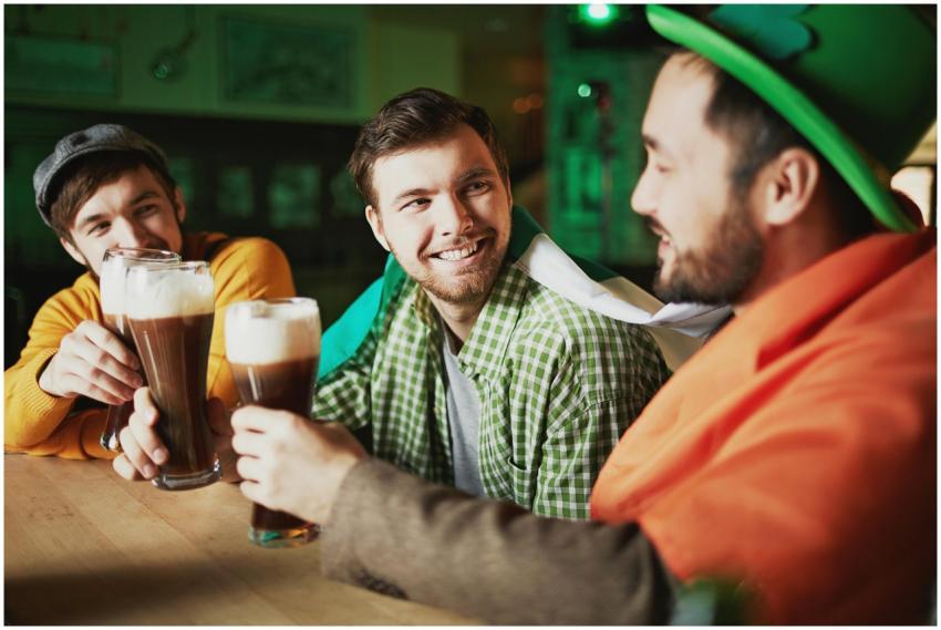 Three friends enjoying beers in an Irish pub, cele