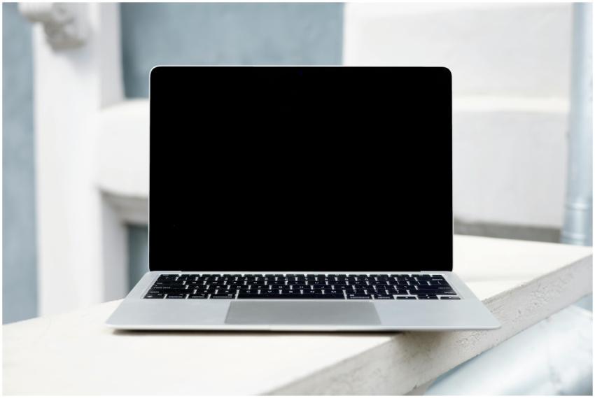 A sleek laptop with a blank screen on a white surf