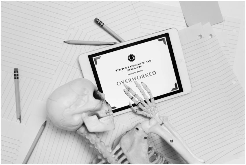 Black and white image of skeleton hand holding tab