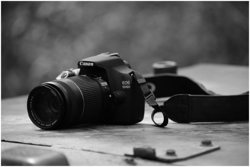 Monochrome close-up of DSLR camera placed on a tex