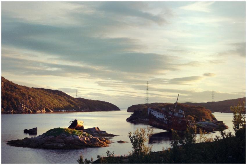 A serene landscape view of a shipwreck on a distan