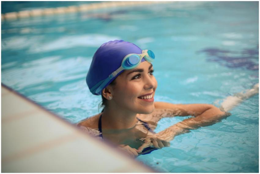 Young woman in a swimming pool, wearing goggles an