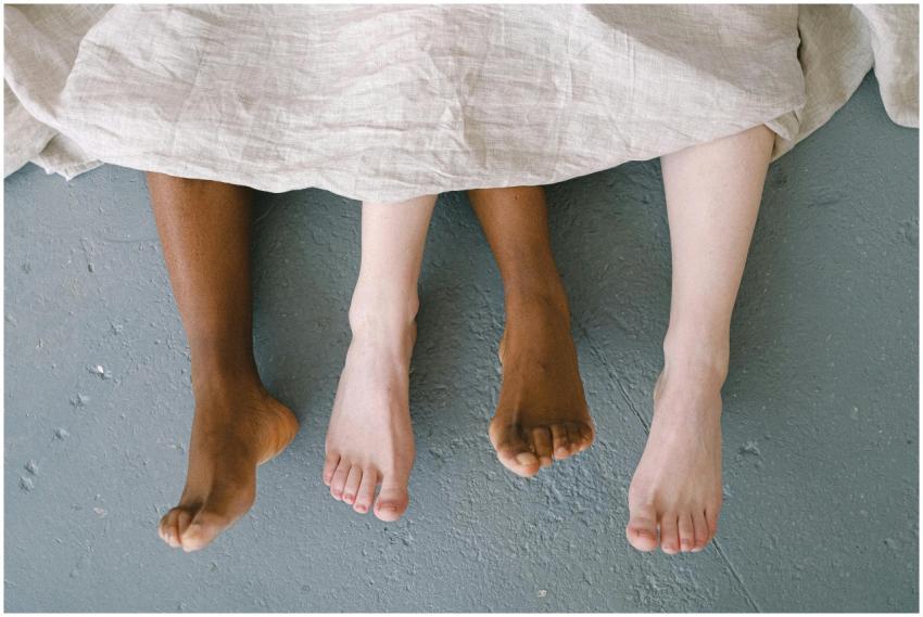 Feet of an interracial couple lying on the floor,