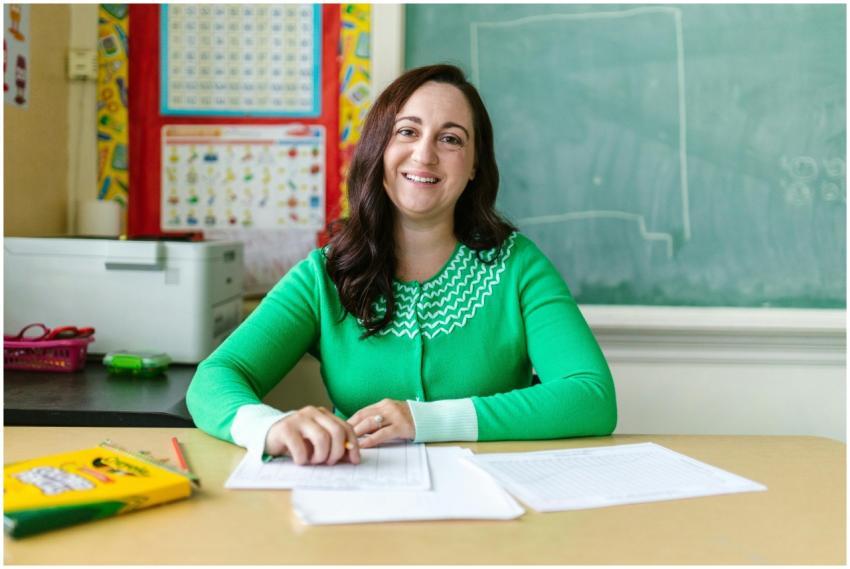 Engaging image of a smiling teacher seated at a de