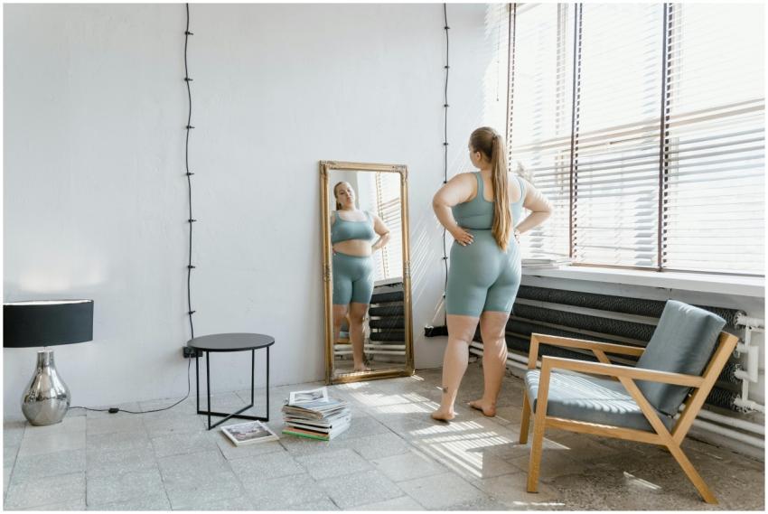 Plus size woman in sportswear stands barefoot, loo