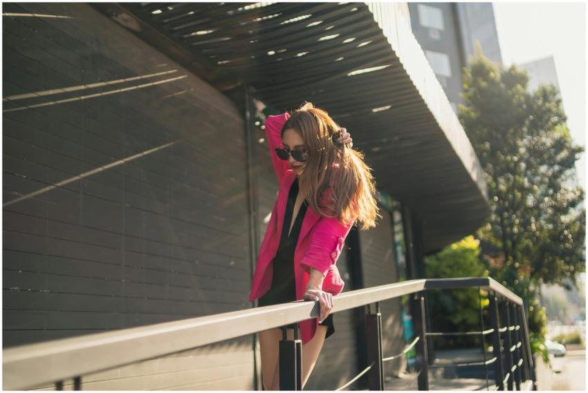 Fashionable woman in pink blazer enjoying a sunny