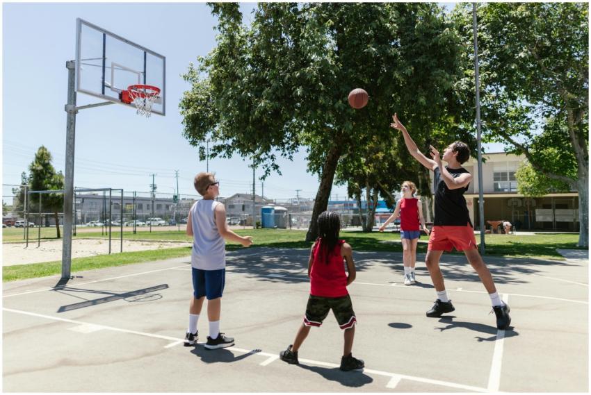 Group of children playing basketball on a sunny ou