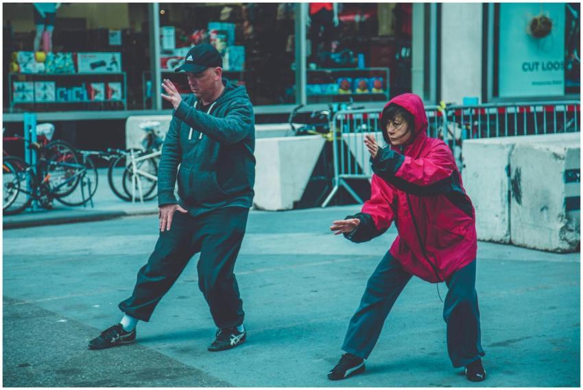 Two adults practicing martial arts on the street,