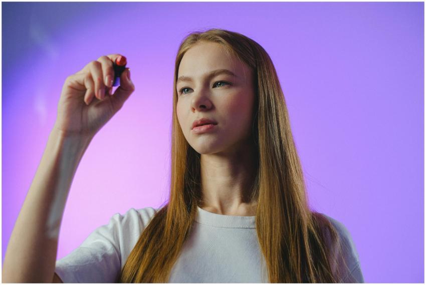 Studio portrait of a teenage girl holding a pen ag