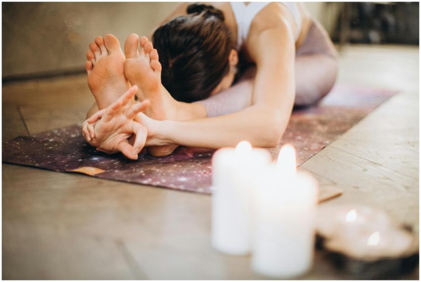 A woman performing yoga with candles, focusing on