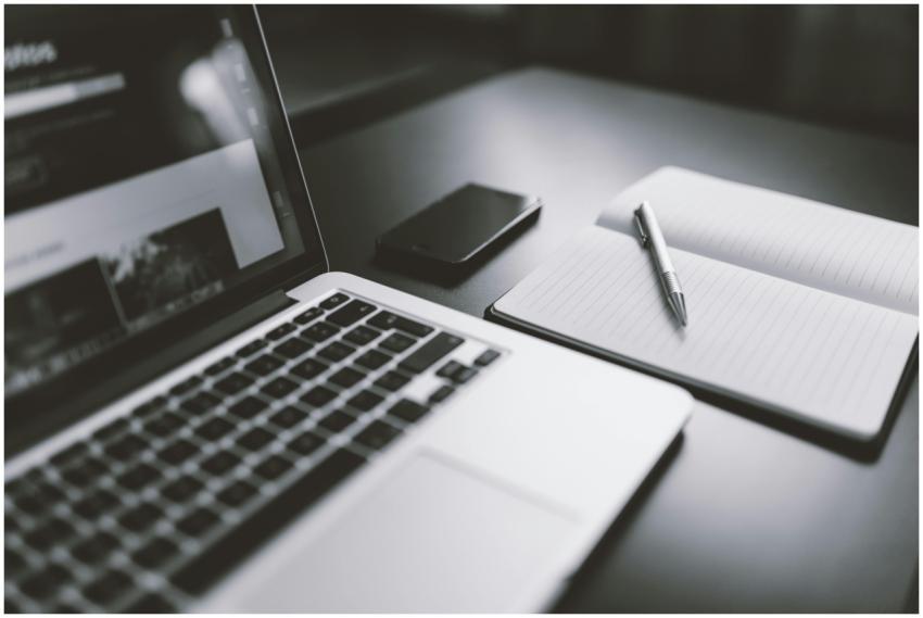 A sleek black and white workspace featuring a lapt