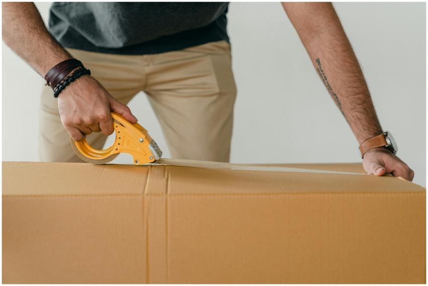 Crop anonymous young male packer in casual clothes