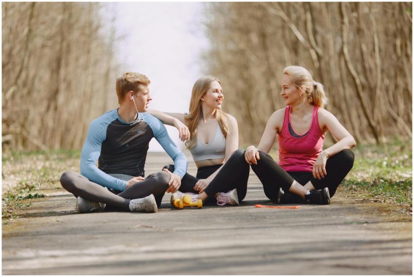 Three friends in sportswear sitting and conversing