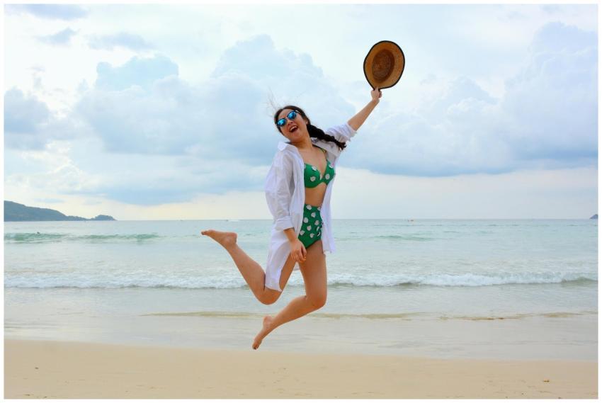 Woman jumps joyfully on a Phuket beach in summer,