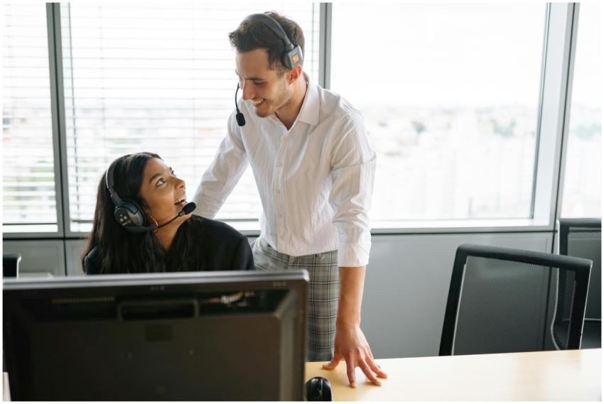 Smiling colleagues wearing headsets working togeth