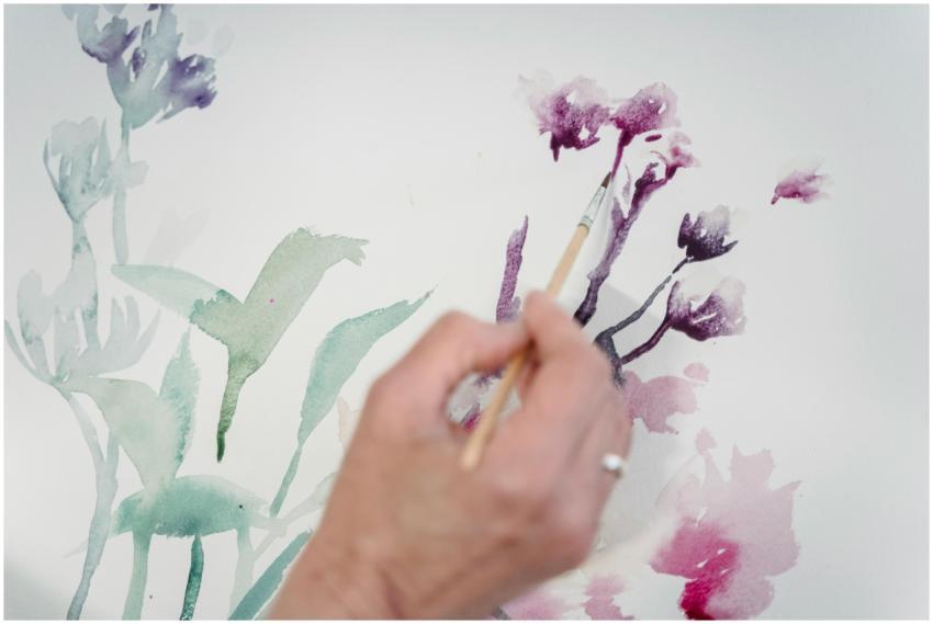 A hand painting vibrant florals with watercolors,