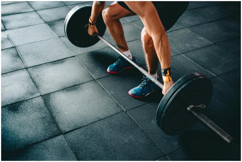 Young man lifting a heavy barbell during an intens