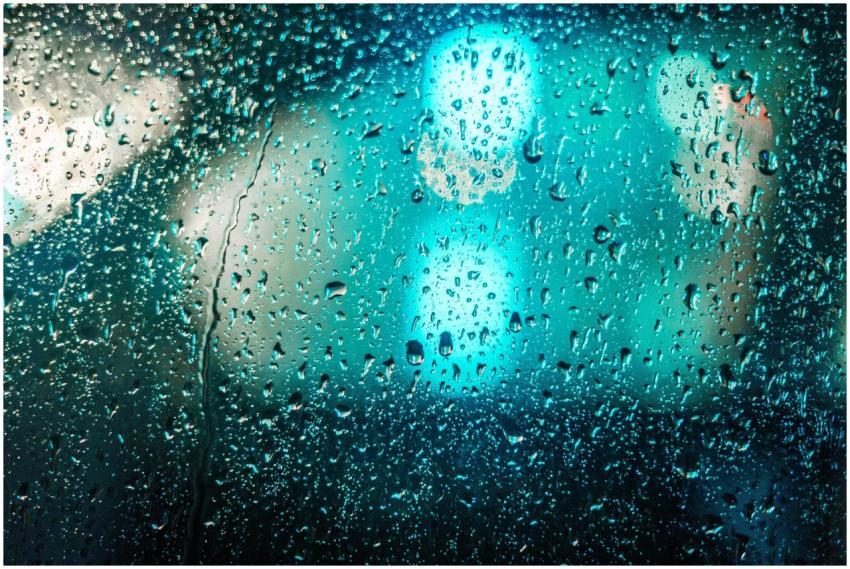 Raindrops on glass with blurred colorful lights cr