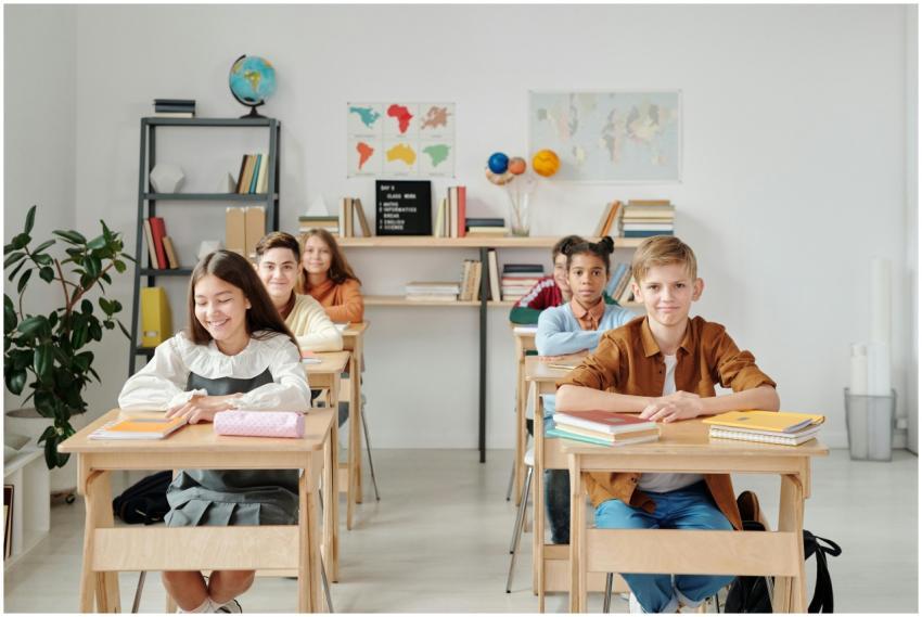 A group of happy students sitting at desks in a mo