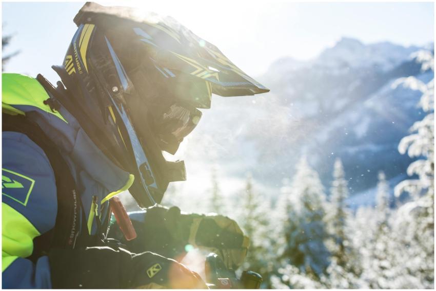 A person snowmobiling in a snowy mountain landscap