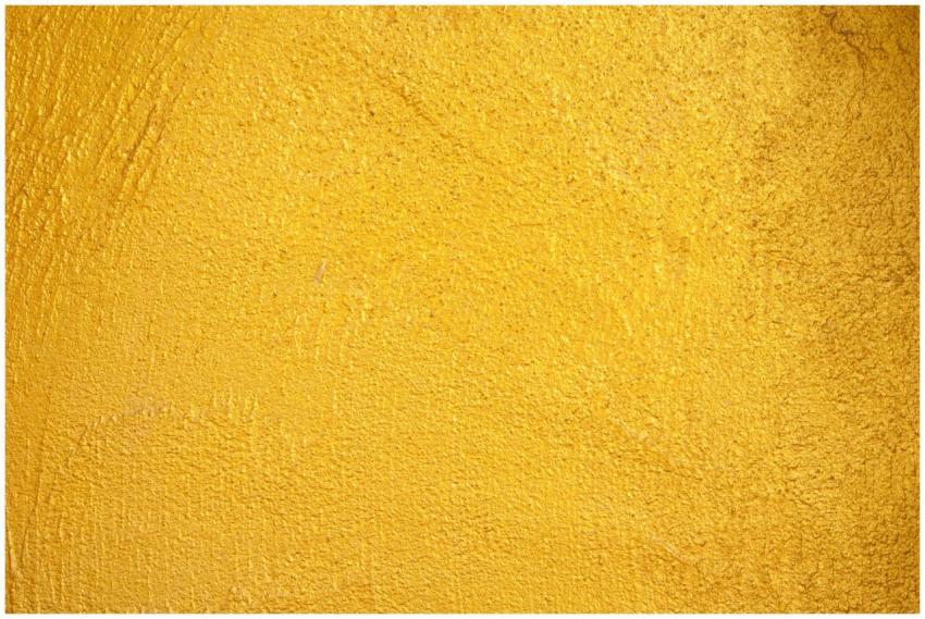 A close-up of a vibrant yellow textured wall, perf