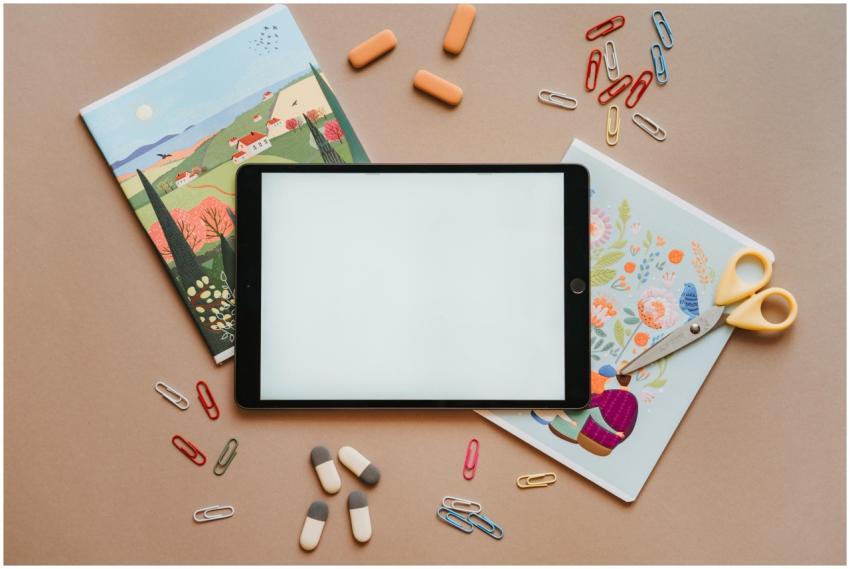 Flat lay of colorful stationery with tablet, noteb