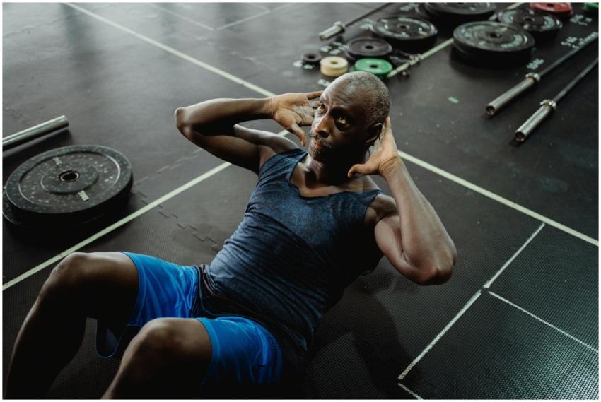 Elderly man exercising indoors performing sit-ups