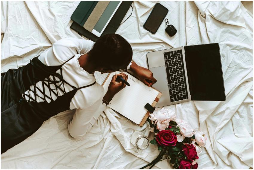 African woman working remotely on laptop with note