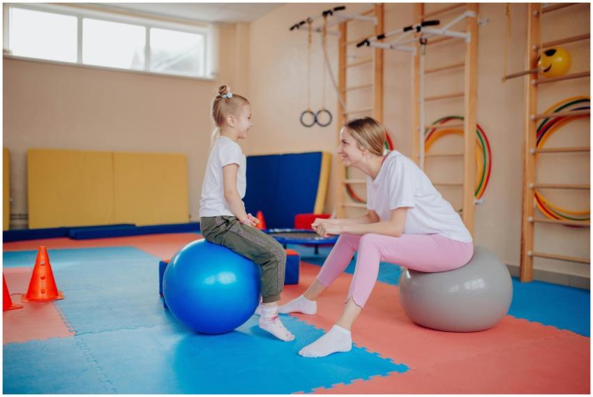 Happy mother and daughter bonding on exercise ball
