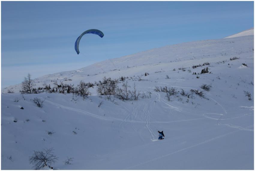 A thrilling sight of kitesurfing on a snowy mounta