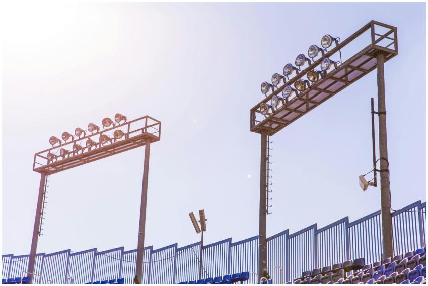 Bright stadium spotlights under a clear blue sky b